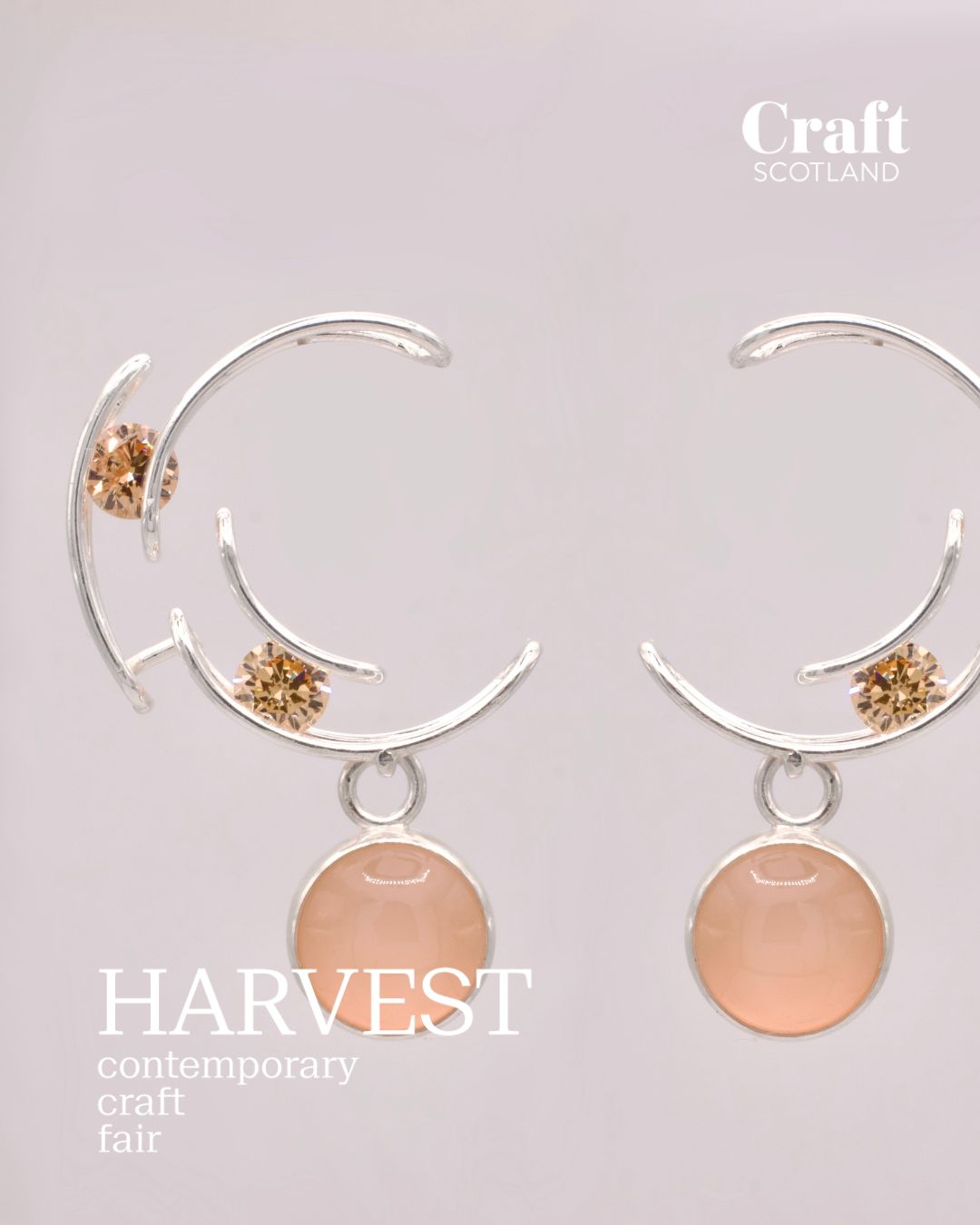 Pair of earrings with pink stones and gold accents on a light gray background, featuring 'Craft Scotland' and 'Harvest contemporary craft fair' text.