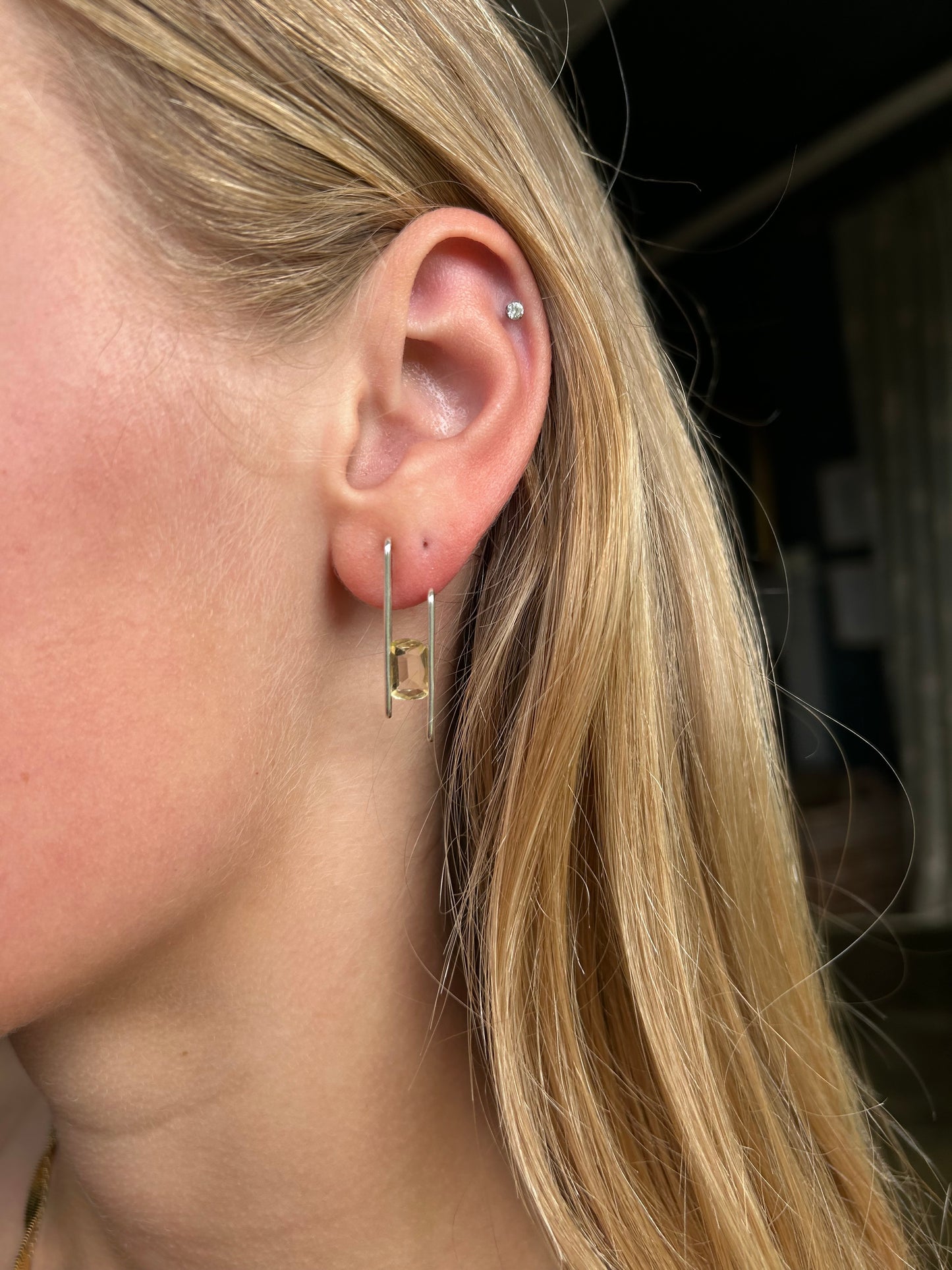 citrine studs being worn by a blonde haired person