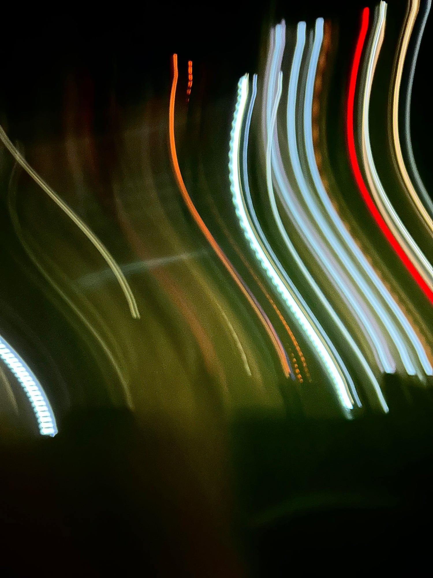 Image of blurred moving colourful lights against a black background 