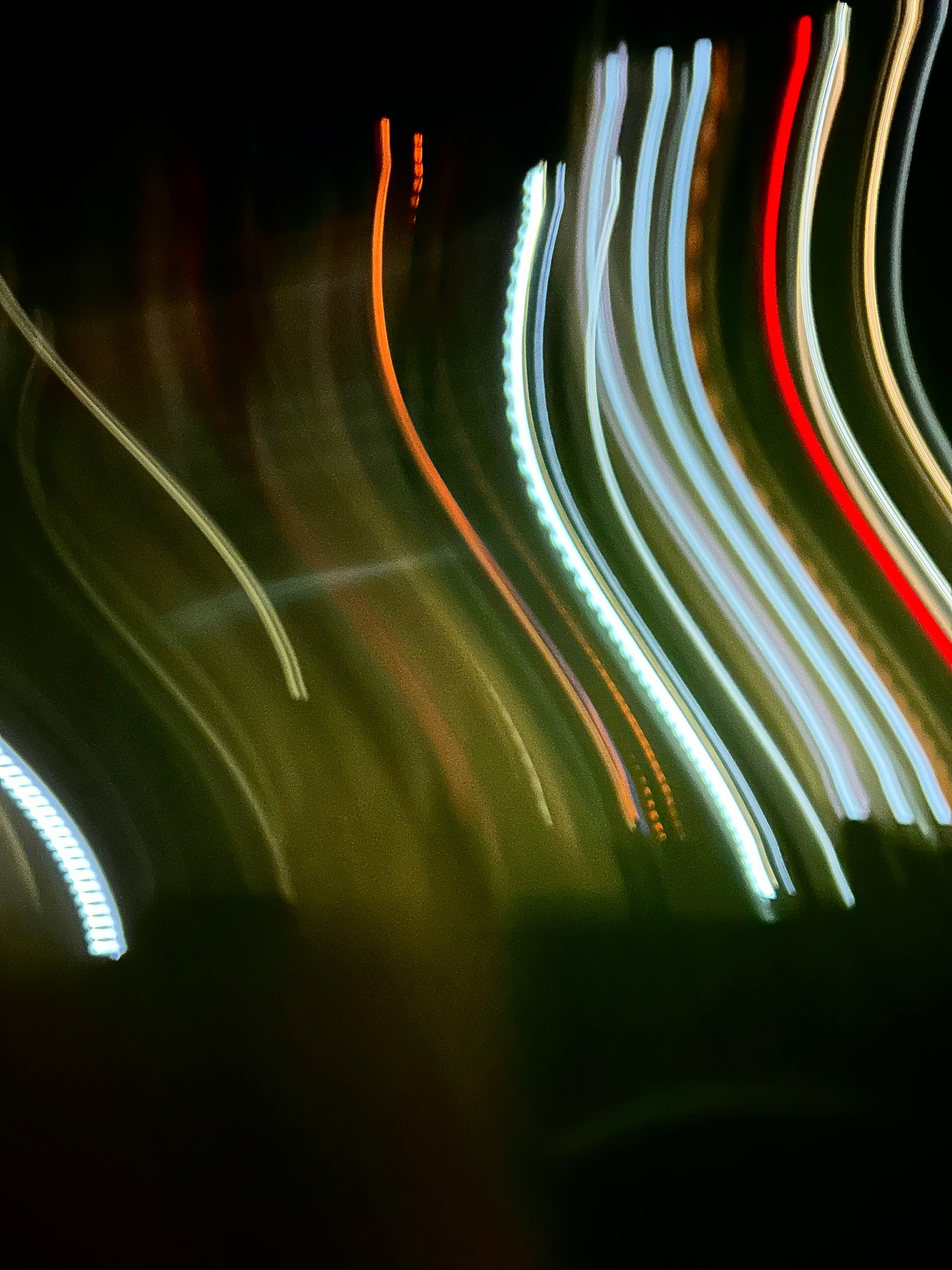 Image of blurred moving colourful lights against a black background 