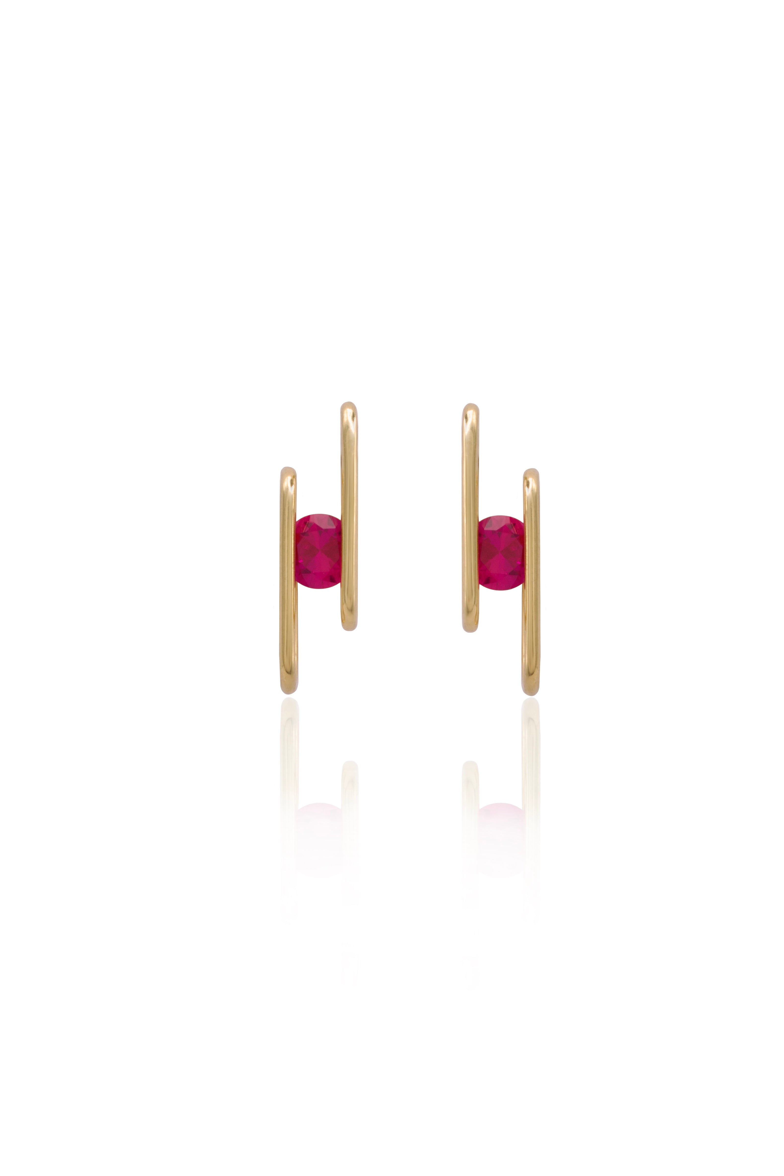 Gold earrings with red gemstones on a white background