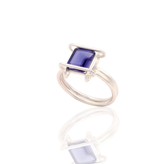 Silver ring with a blue gemstone on a white background