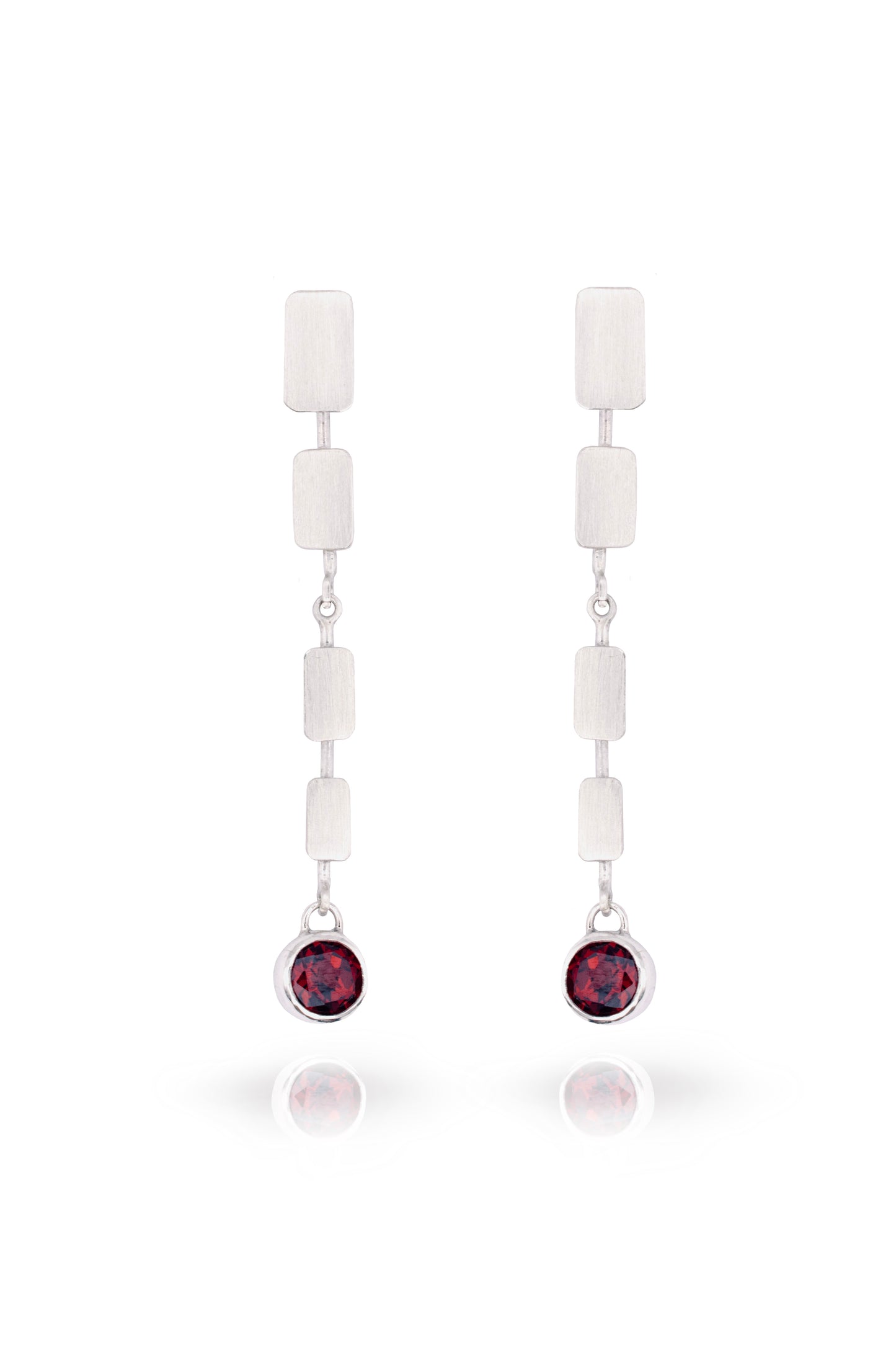 Pair of earrings with white beads and red gemstones on a white background