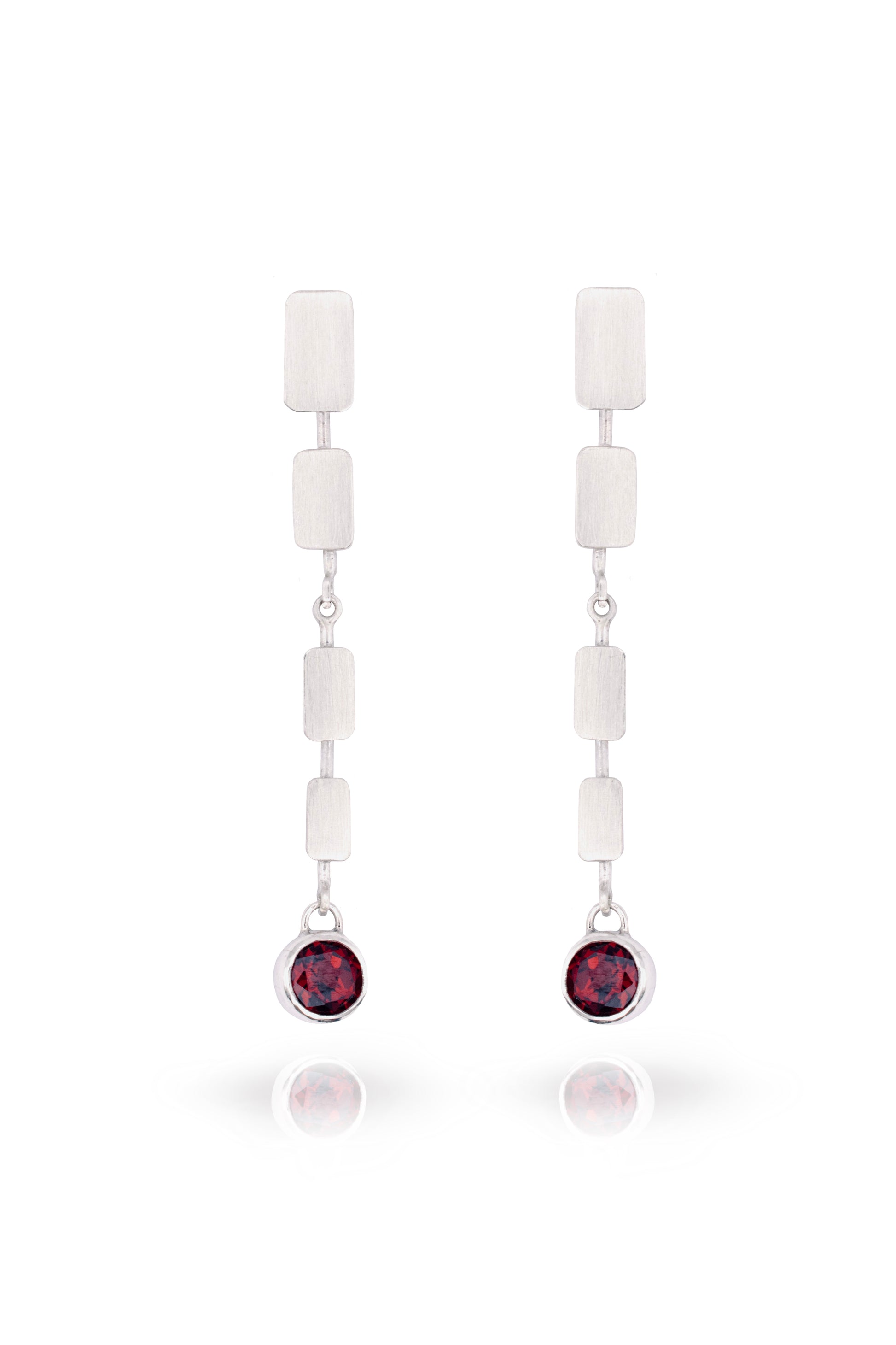 Pair of earrings with white beads and red gemstones on a white background
