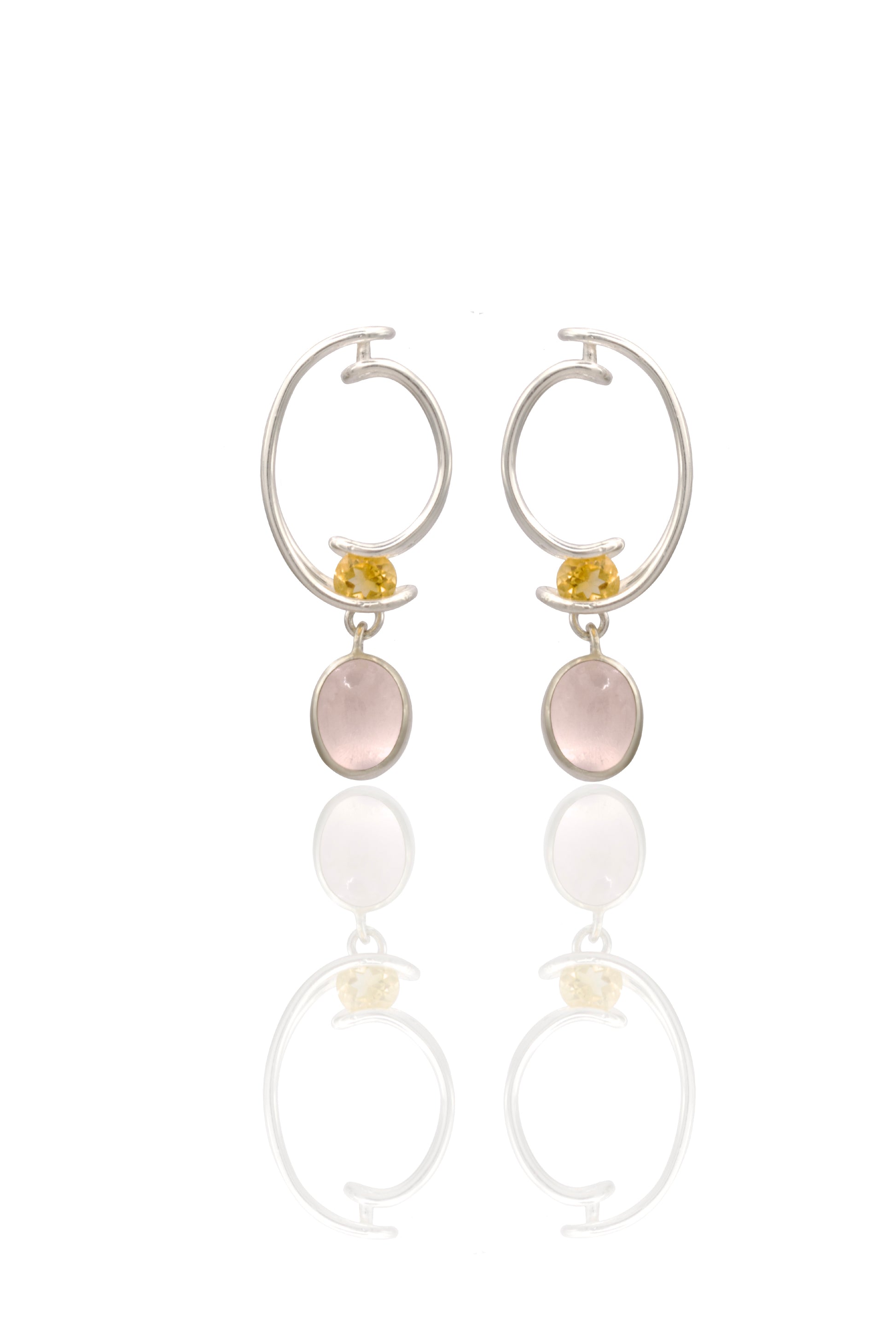 Pair of hoop earrings with round and oval stone drops on a white background