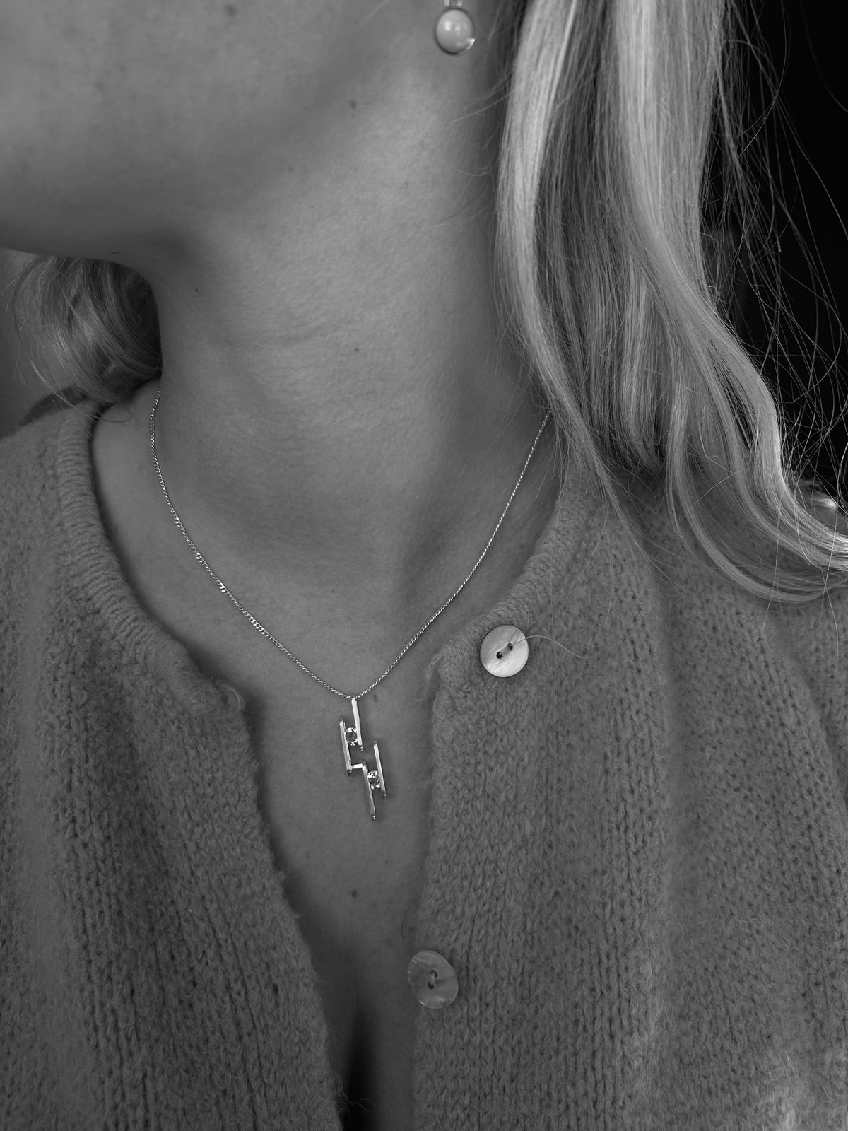 silver necklace with wire pendant being worn
