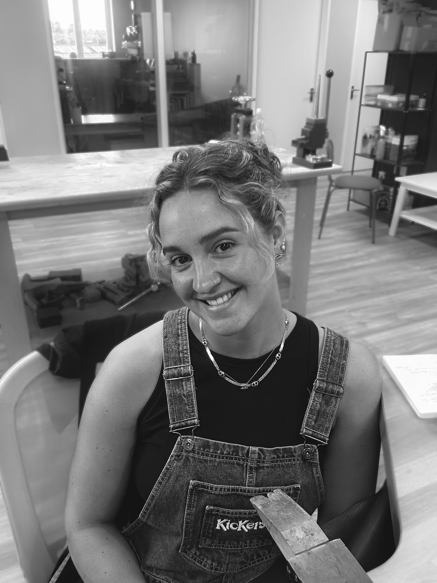 Black and white portrait of Matilda sitting at her bench in the studio 