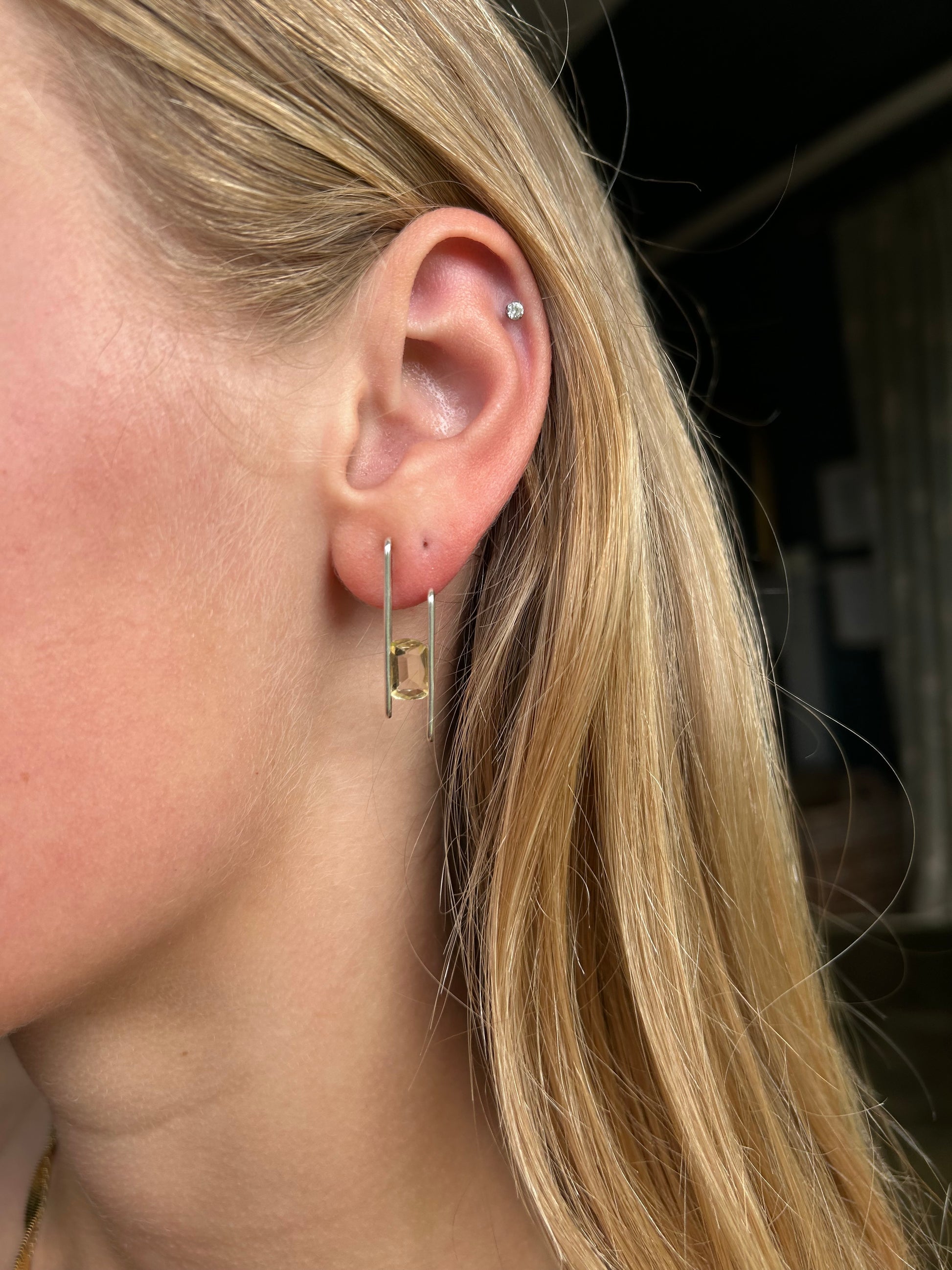 citrine studs being worn by a blonde haired person