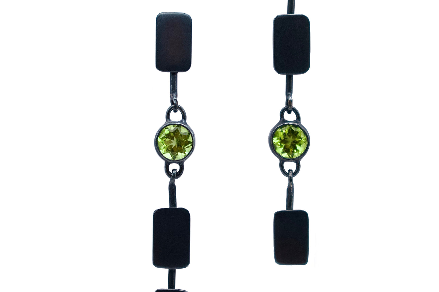 Pair of earrings with black and green gemstones on a white background